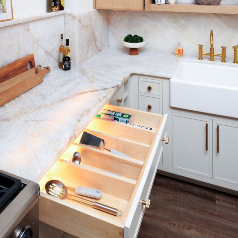 An illuminated drawer system makes finding utensils easier in this high-end kitchen display in Roswell