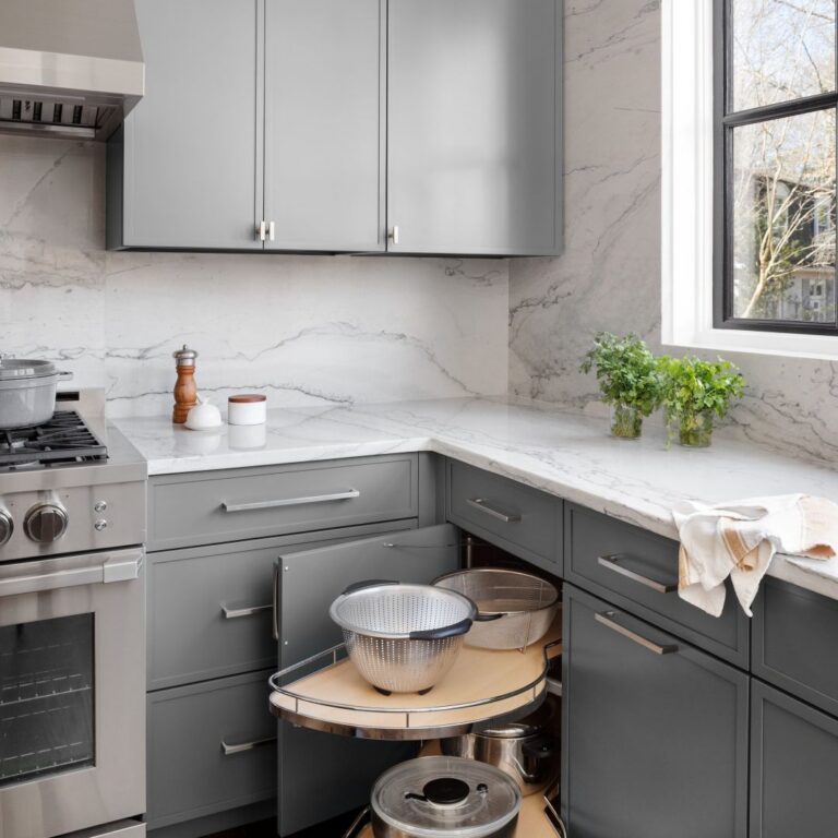 picture of a swing-out lazy Susan in a modern kitchen remodel in buckhead GA featuring grey cabinets, white quartzite with grey veining and luxury appliances