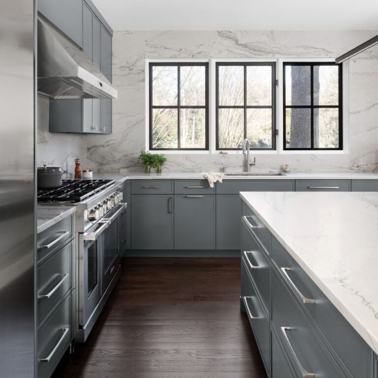 side view of contemporary buckhead kitchen renovation showing grey cabinets and luxury appliances looking toward sink and showing windows with black frames