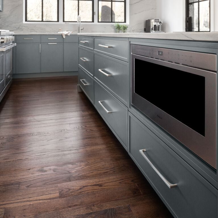 picture of lower cabinets showing steam drawer, stainless steel fridge, grey modern cabinets with brushed nickel hardware