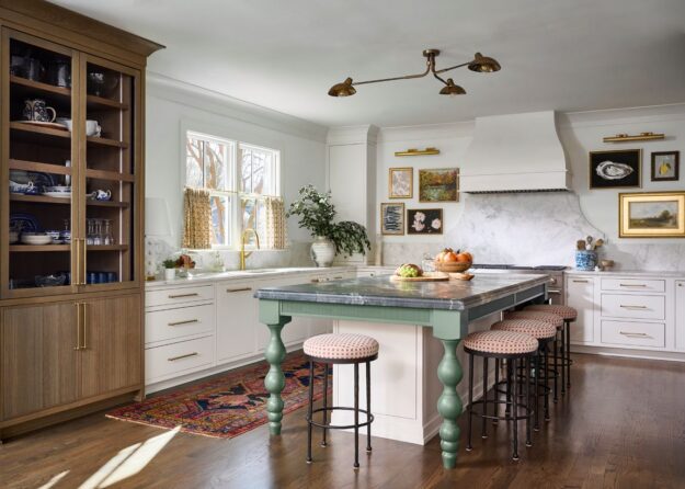 Atlanta kitchen remodel with custom cabinetry, marble backsplash, brass hardware, furniture-style green island, warm wood display cabinet, and layered traditional-modern design details