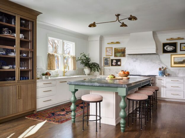 Atlanta kitchen remodel with custom cabinetry, marble backsplash, brass hardware, furniture-style green island, warm wood display cabinet, and layered traditional-modern design details