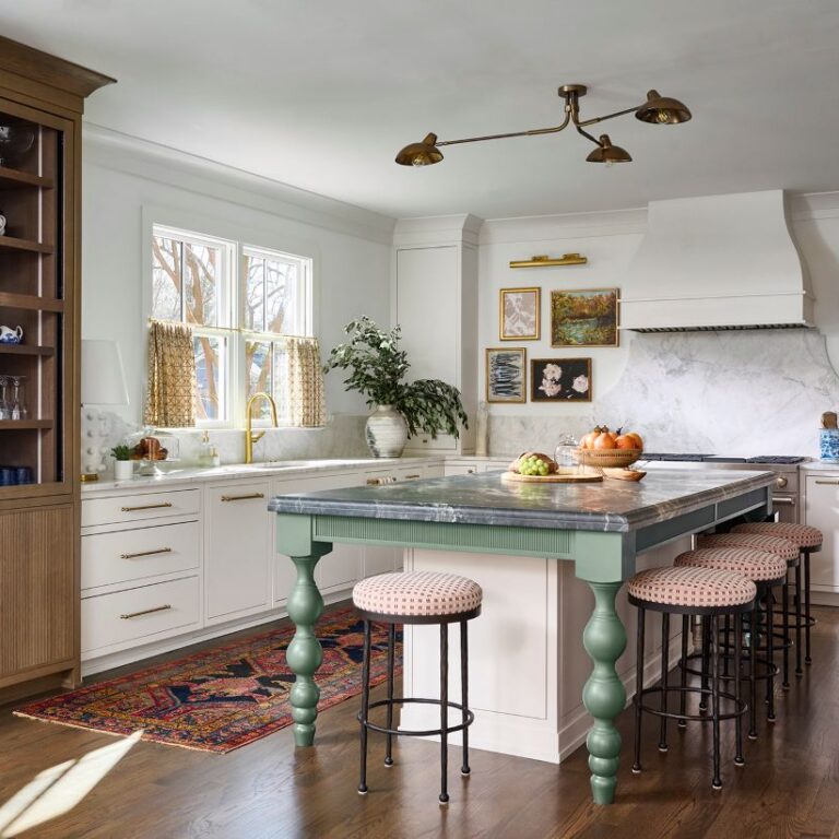 Atlanta kitchen remodel with custom cabinetry, marble backsplash, brass hardware, furniture-style green island, warm wood display cabinet, and layered traditional-modern design details