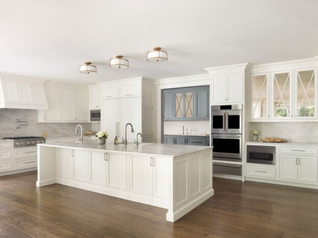 Angled view of white transitional Roswell kitchen with large island and blue-gray prep area