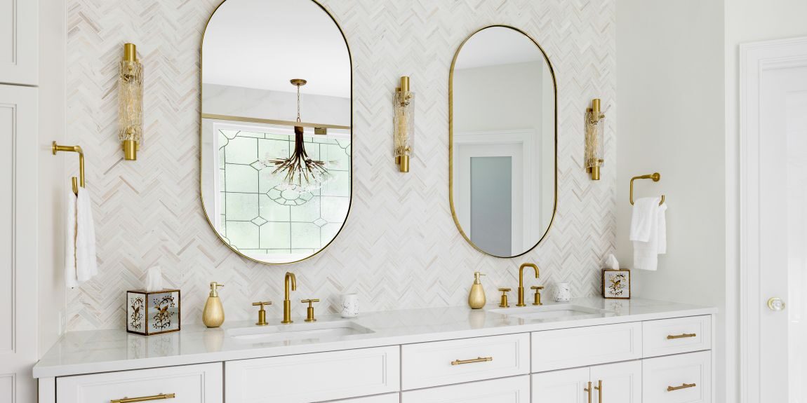 Custom white double vanity with quartz countertop, arched mirrors, and brushed-gold fixtures